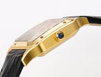 Gold-tone watch case side with blue detail accent and black leather strap