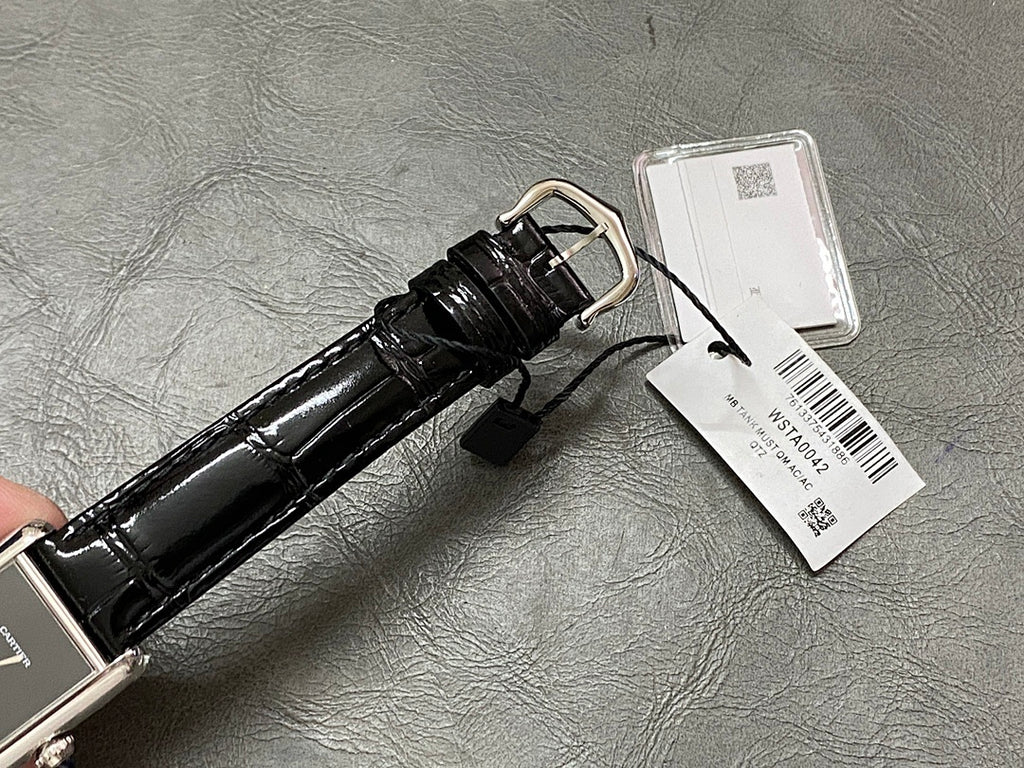 Cartier watch strap view with black leather, silver buckle, and white barcode tag on back