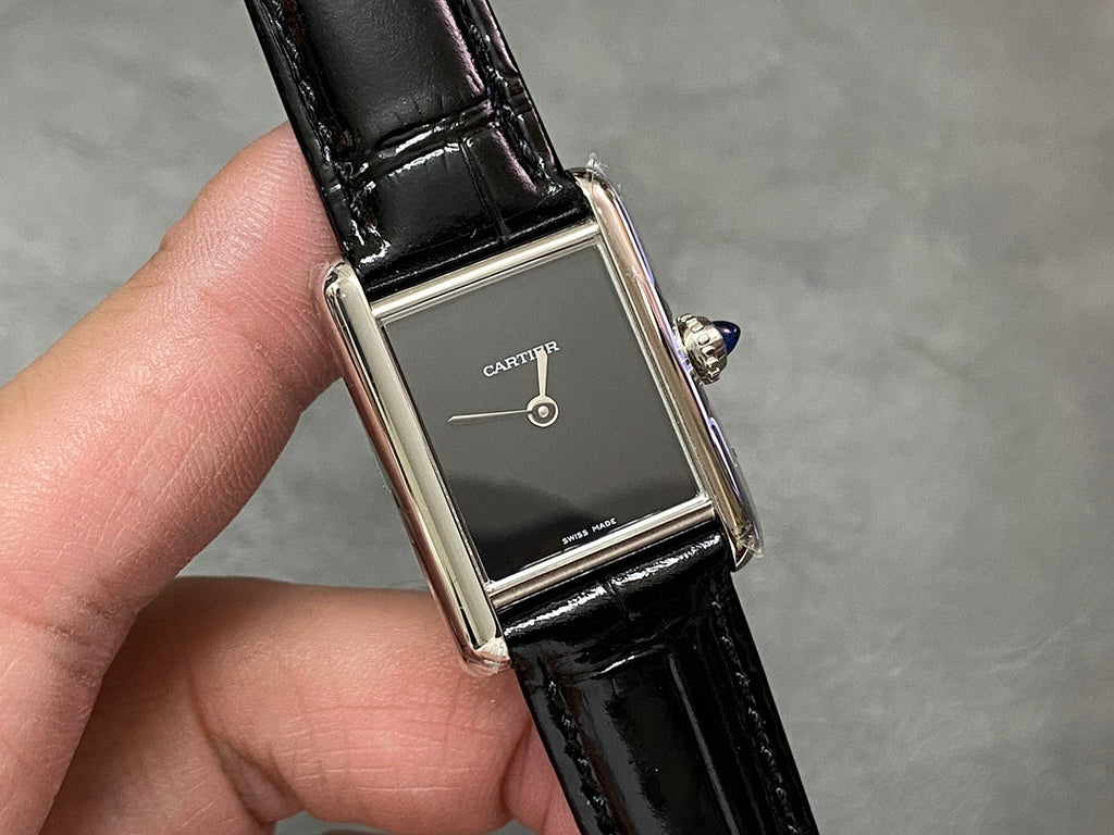 Cartier rectangular watch on black leather strap, silver case, dark dial and crown
