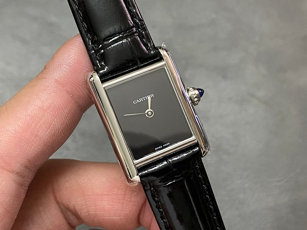 Cartier rectangular watch on black leather strap, silver case, dark dial and crown