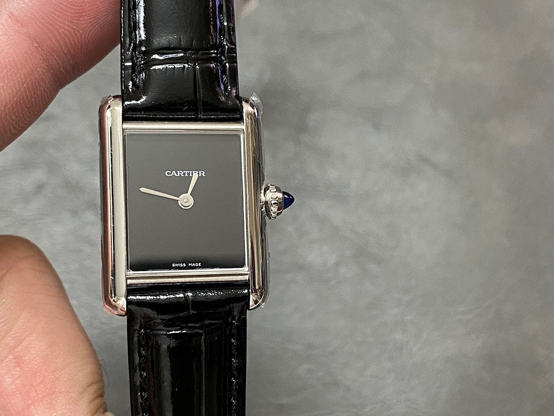 Cartier rectangular watch with black leather strap, silver case, dark dial and crown