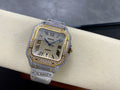 Cartier watch with glittery silver strap, gold bezel, blue hands, Roman numerals and square dial