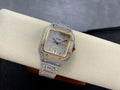 Square luxury wristwatch with diamond bezel, gold trim, blue dial, and light gray strap
