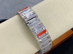 Silver-toned square watch with gold trim, blue dial, red accent in strap, side view