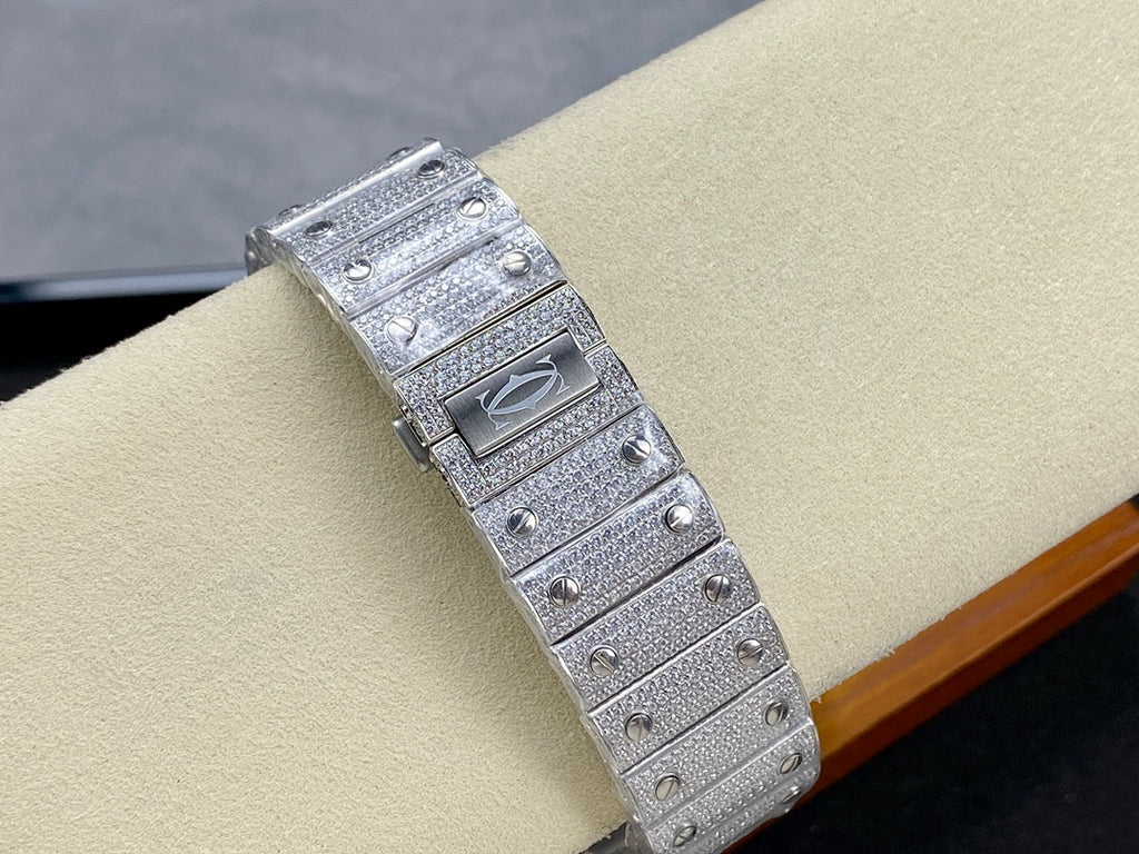 Cartier watch with rectangular jeweled case and signed bezel, silver-tone strap, side view.