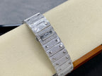 Cartier watch with rectangular jeweled case and signed bezel, silver-tone strap, side view.