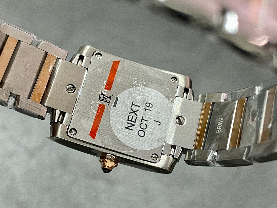 Cartier tank watch case back with engraved markings and metal bracelet, close-up