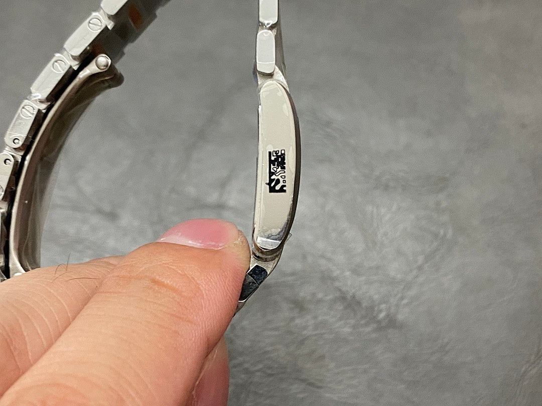 Cartier watch side with engraved logo and polished metal case, close-up