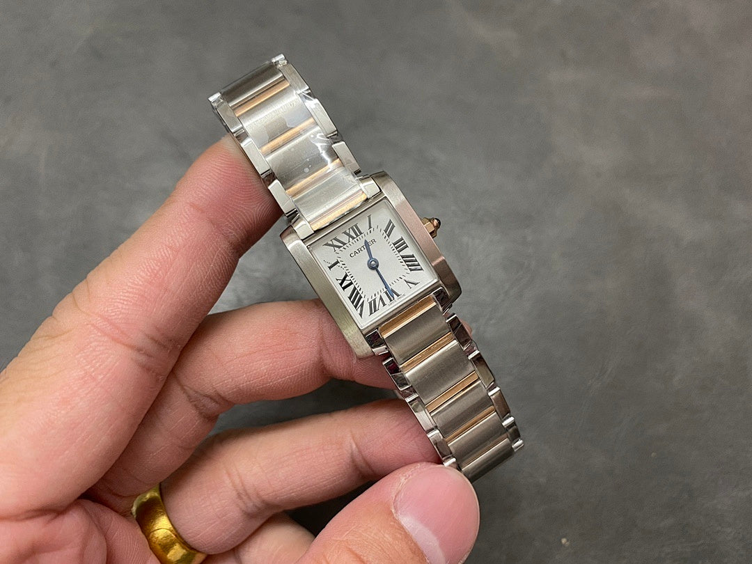 Cartier tank-style watch with silver Roman numeral dial and metal bracelet, angled view