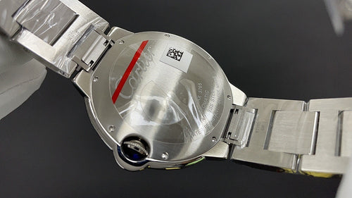 Cartier watch caseback close-up on metal bracelet, with engraved back and crown-side details