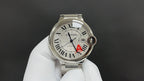 Cartier watch front view with silver Roman numeral dial, blue hands, red A accent, steel strap