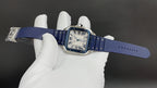 Cartier square watch with blue leather strap and silver case, held flat