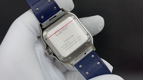 Cartier watch case back with engraved text and blue leather strap on white glove