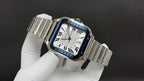 Square stainless steel Cartier watch with blue accents and Roman numeral dial on bracelet