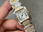 Close-up two-tone wristwatch with white dial, Roman numerals, and blue-tinted hands