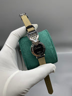 Cartier watch with black leather strap and round dial showing Cartier lettering