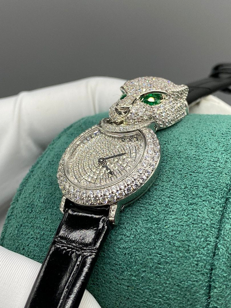 Cartier watch close-up with green cat head, emerald eyes, and round diamond dial