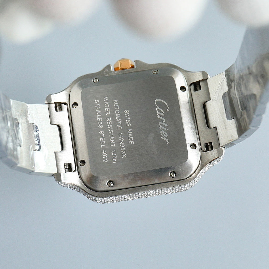 Cartier watch case back with Cartier branding, diamond-set bezel, silver bracelet links.