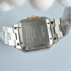 Cartier watch case back with Cartier branding, diamond-set bezel, silver bracelet links.