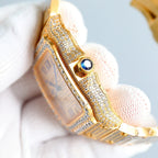 Cartier wristwatch side view with diamond-studded case, blue gemstone accent, gold bracelet links