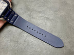 Blue leather watch strap with rows of small metal rivets and punched sizing holes