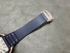 Blue leather watch strap with metal buckle clasp on a silver-toned keeper