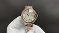 Cartier watch with light dial, gold-toned bezel, and metal bracelet with round crown