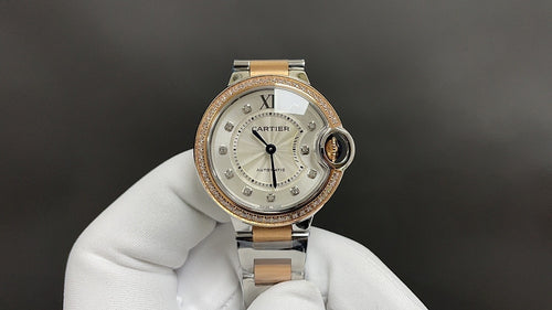 Cartier watch with light dial, gold-toned bezel, and metal bracelet with round crown