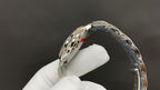 Cartier watch with silver-tone bracelet links and curved bezel setting