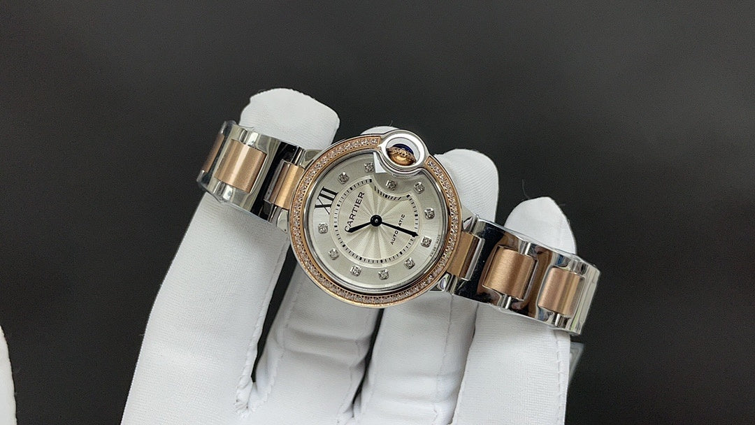 Cartier watch with silver bracelet links, gold-toned details, and jeweled bezel