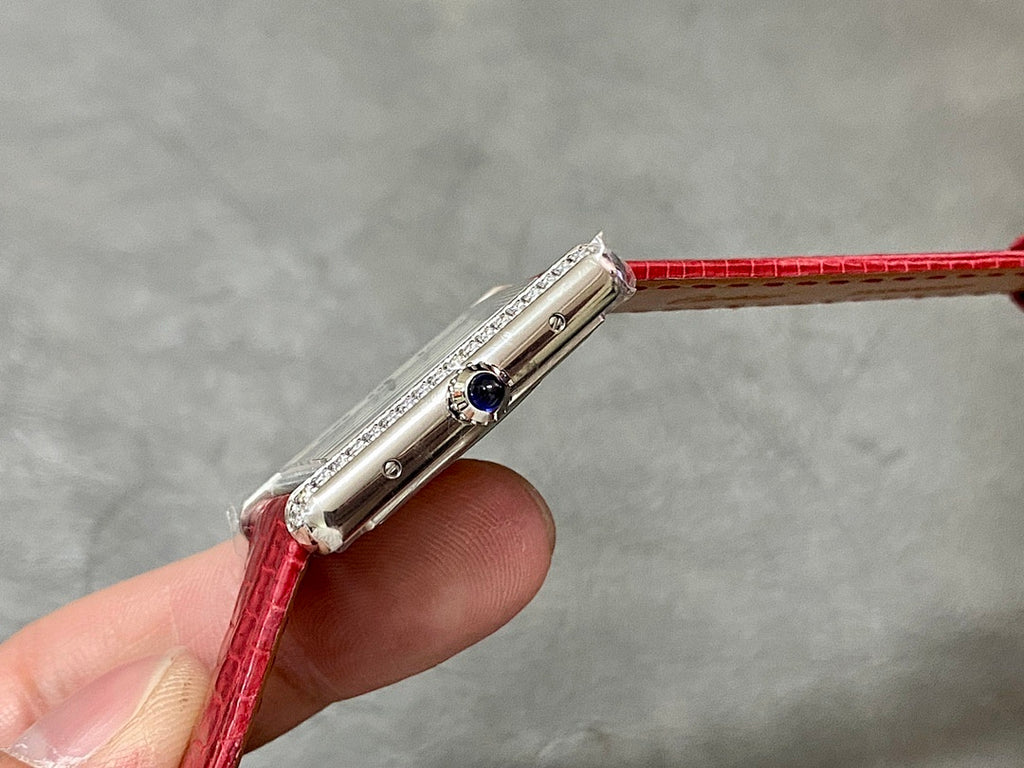 Cartier watch side profile with jeweled bezel, crown, and red leather strap