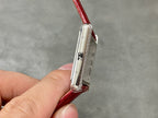 Cartier watch slim side view with blue-toned crown and red crocodile leather strap