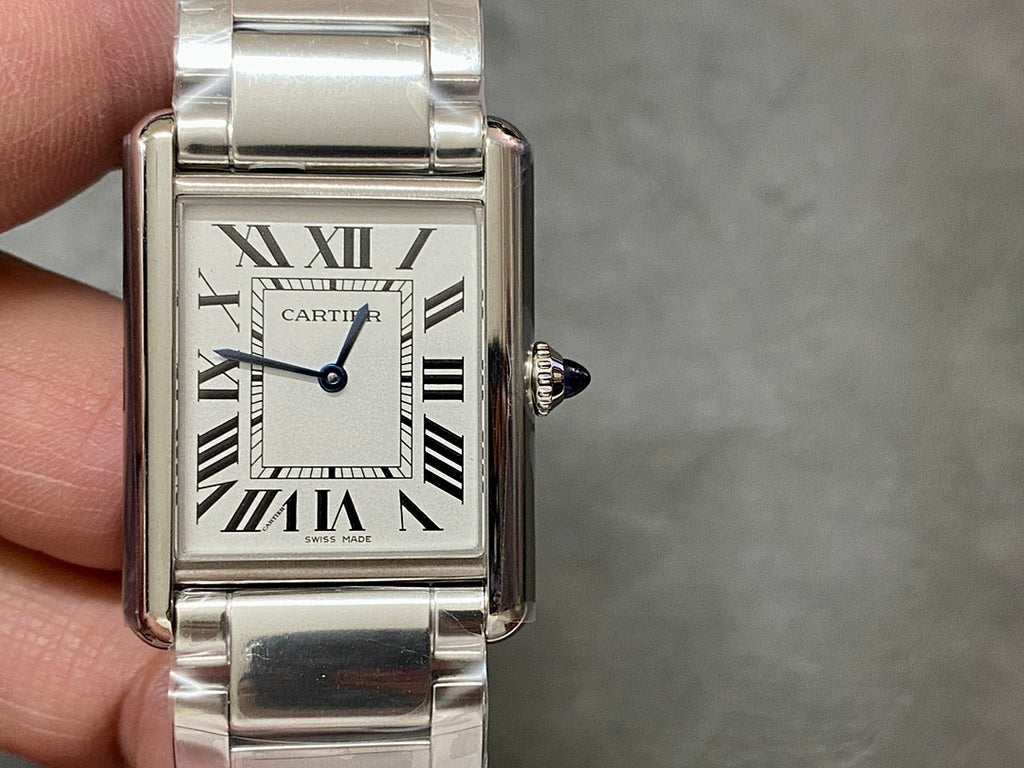Rectangular stainless steel wristwatch on wrist with Roman numeral dial and crown