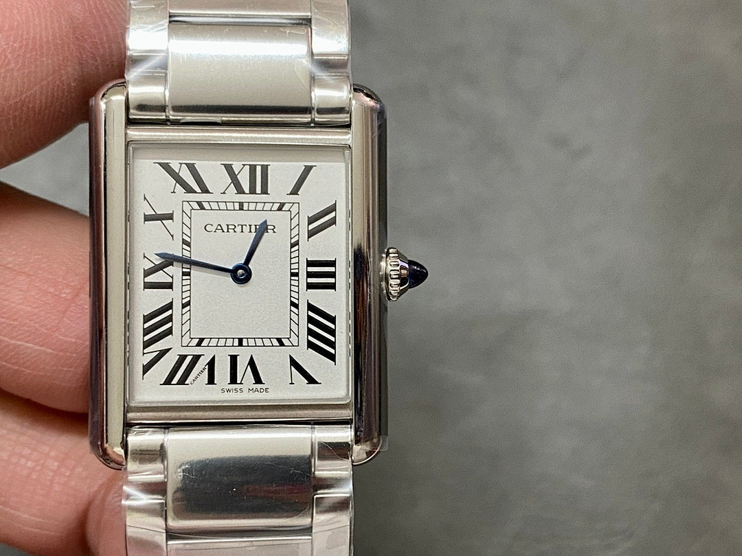 Rectangular stainless steel wristwatch on wrist with Roman numeral dial and crown