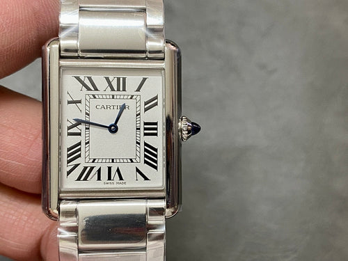 Rectangular stainless steel wristwatch on wrist with Roman numeral dial and crown