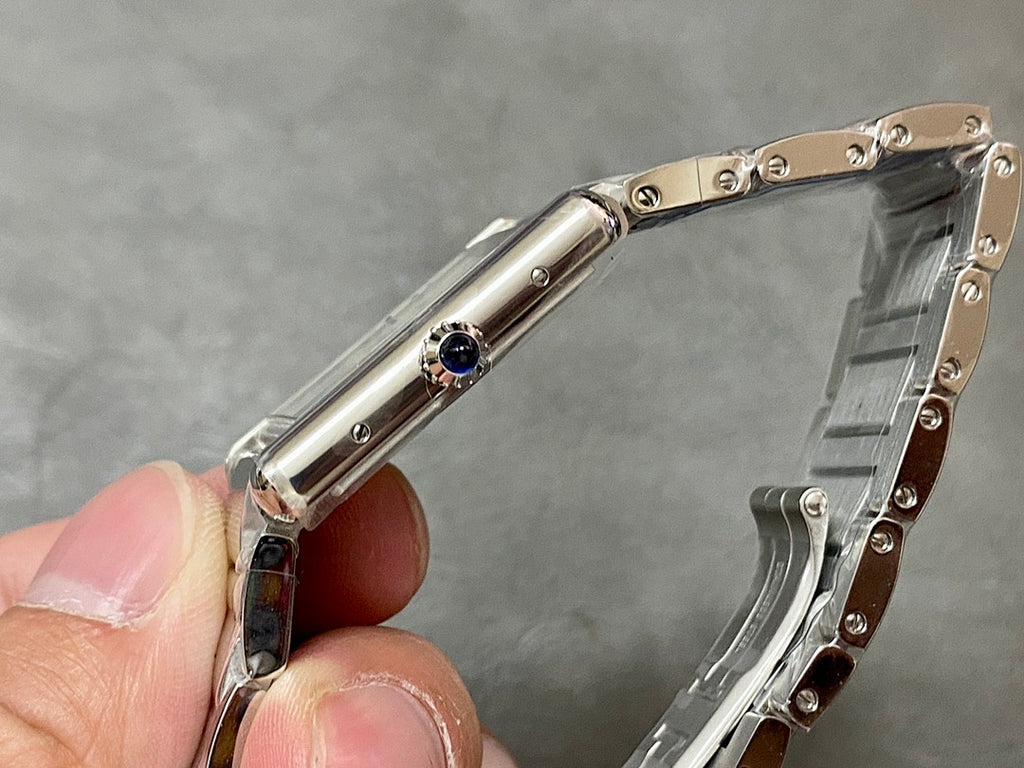 Stainless steel wristwatch side profile with crown and circular blue jewel