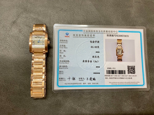 Gold-tone Cartier watch beside a certification card with printed watch details