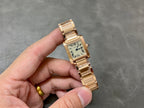 Gold-tone Cartier wristwatch with rectangular dial, Roman numerals, and linked bracelet