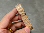 Gold-tone Cartier watch bracelet with polished links and clasp, held in hand