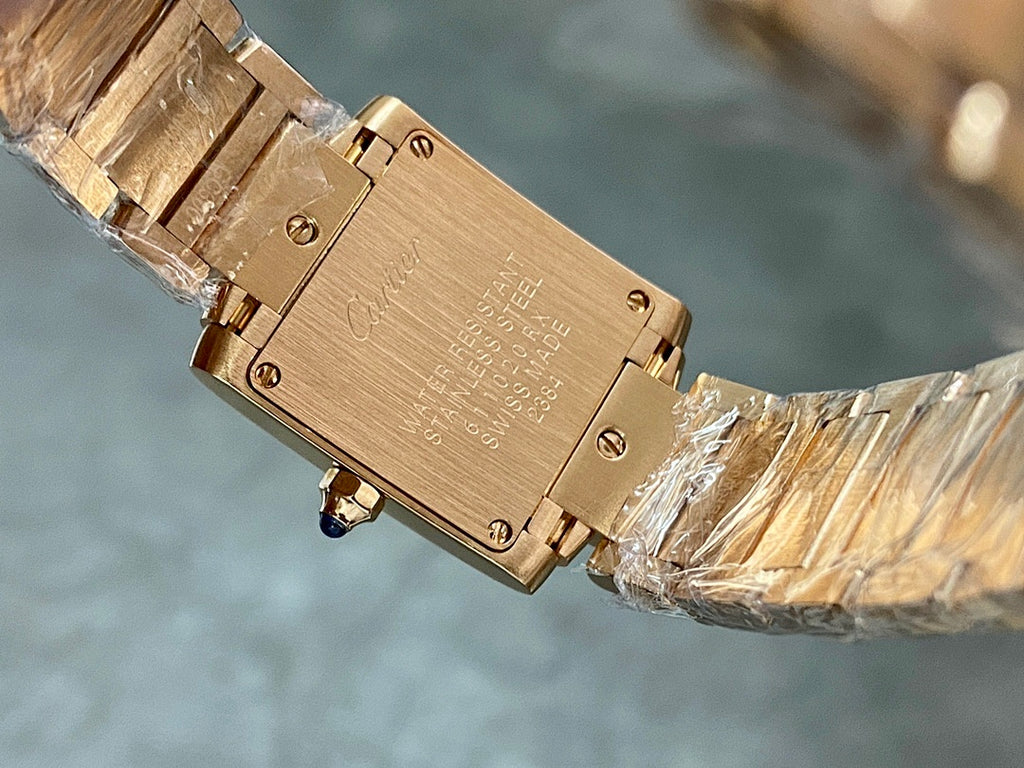 Engraved gold-tone Cartier watch caseback with screws, wrapped for protection