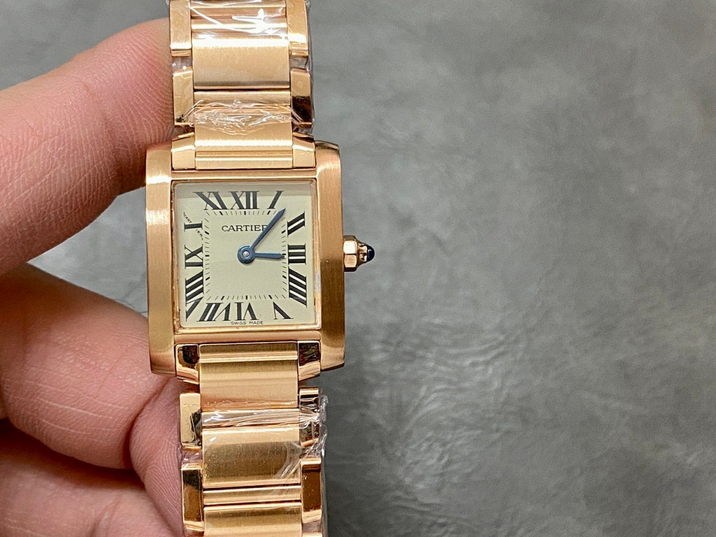 Gold-tone Cartier watch with rectangular cream dial and Roman numerals, held up