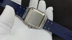 Wristwatch with blue rubber strap and gold-tone rectangular case, clasp and screws