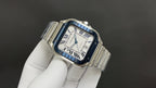 Cartier watch angled view, blue dial Roman numerals, stainless steel bracelet