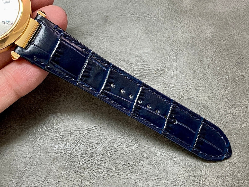 Blue leather watch strap with stitched edges and gold-tone buckle hardware
