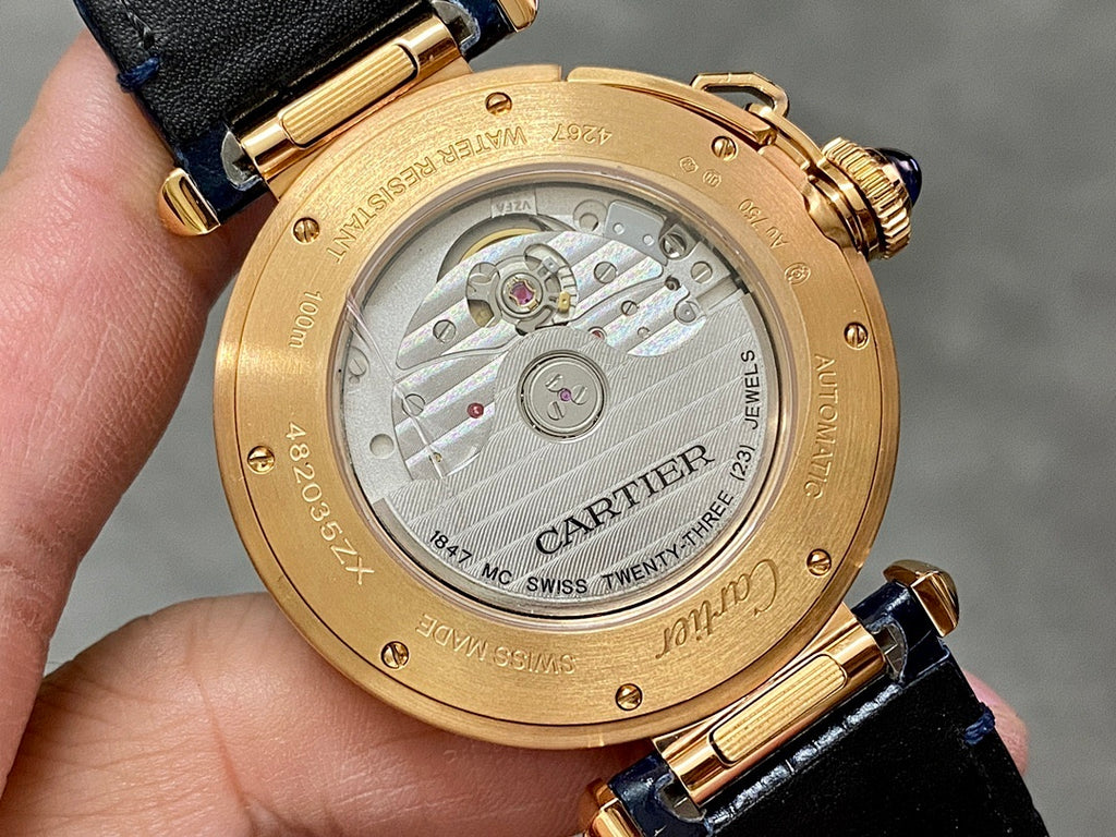 Cartier watch caseback in gold-tone with engraved details and attached blue leather strap