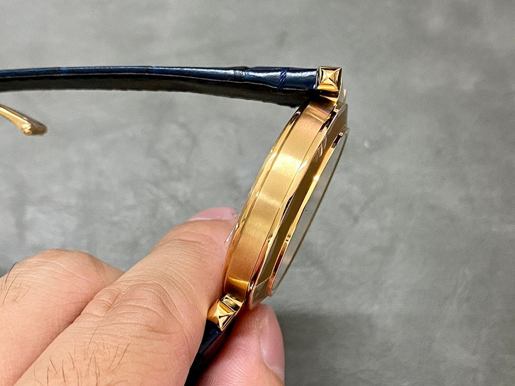 Cartier watch with gold-tone case side profile and blue leather strap, buckle end visible