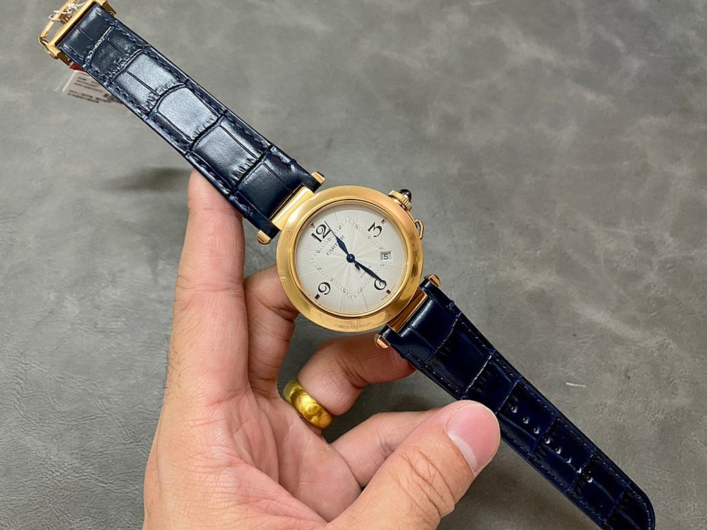 Cartier watch on blue leather strap with gold-tone case and white dial, held in hand
