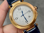 Cartier watch with gold-tone round case, white dial, blue leather strap, close-up face