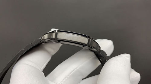 Cartier watch clasp and black leather strap with buckle holes, held by white glove.