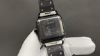 Cartier watch back with engraved case and strap, shown on a white-gloved hand.